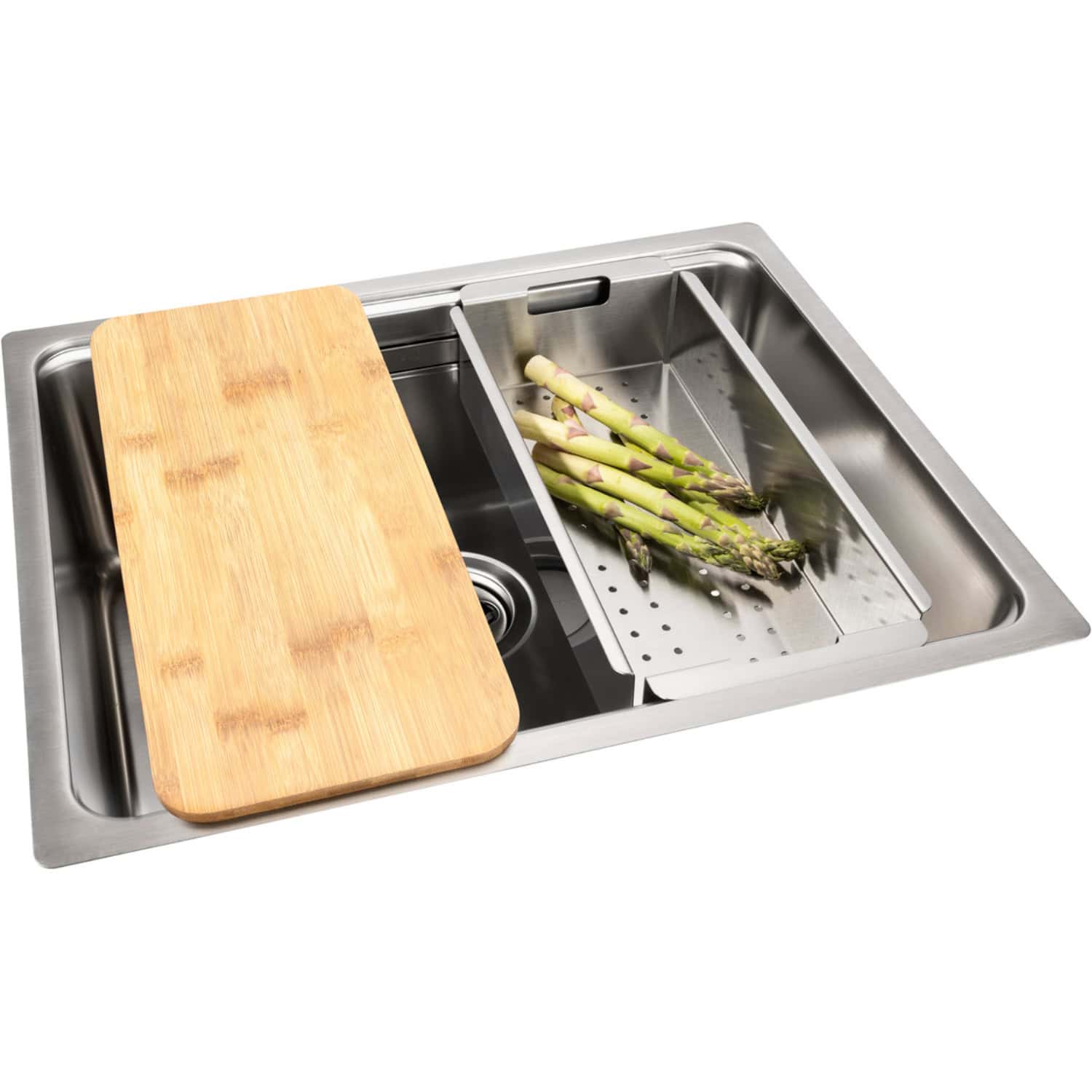 Cutting board and asparagus in stainless steel kitchen sink with drainboard.