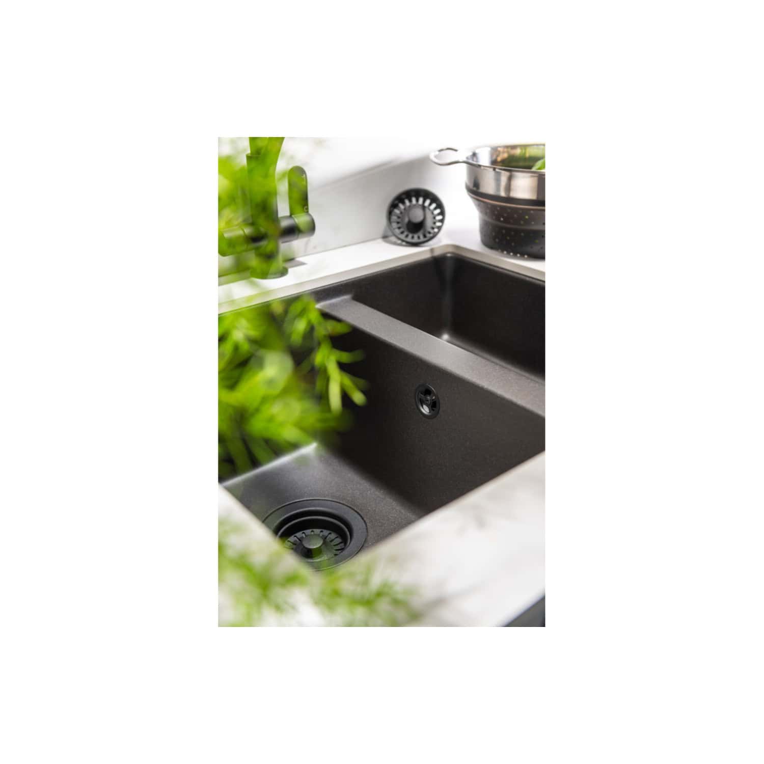 Sleek black kitchen sink with modern design, stainless steel faucet, and eco-friendly surroundings for contemporary bathroom and kitchen renovations.