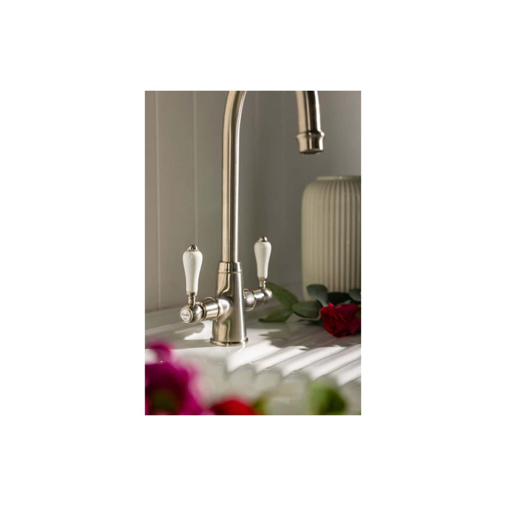 Polished stainless steel kitchen tap with vintage white ceramic handles, modern design perfect for stylish Bubly bathrooms and kitchens.