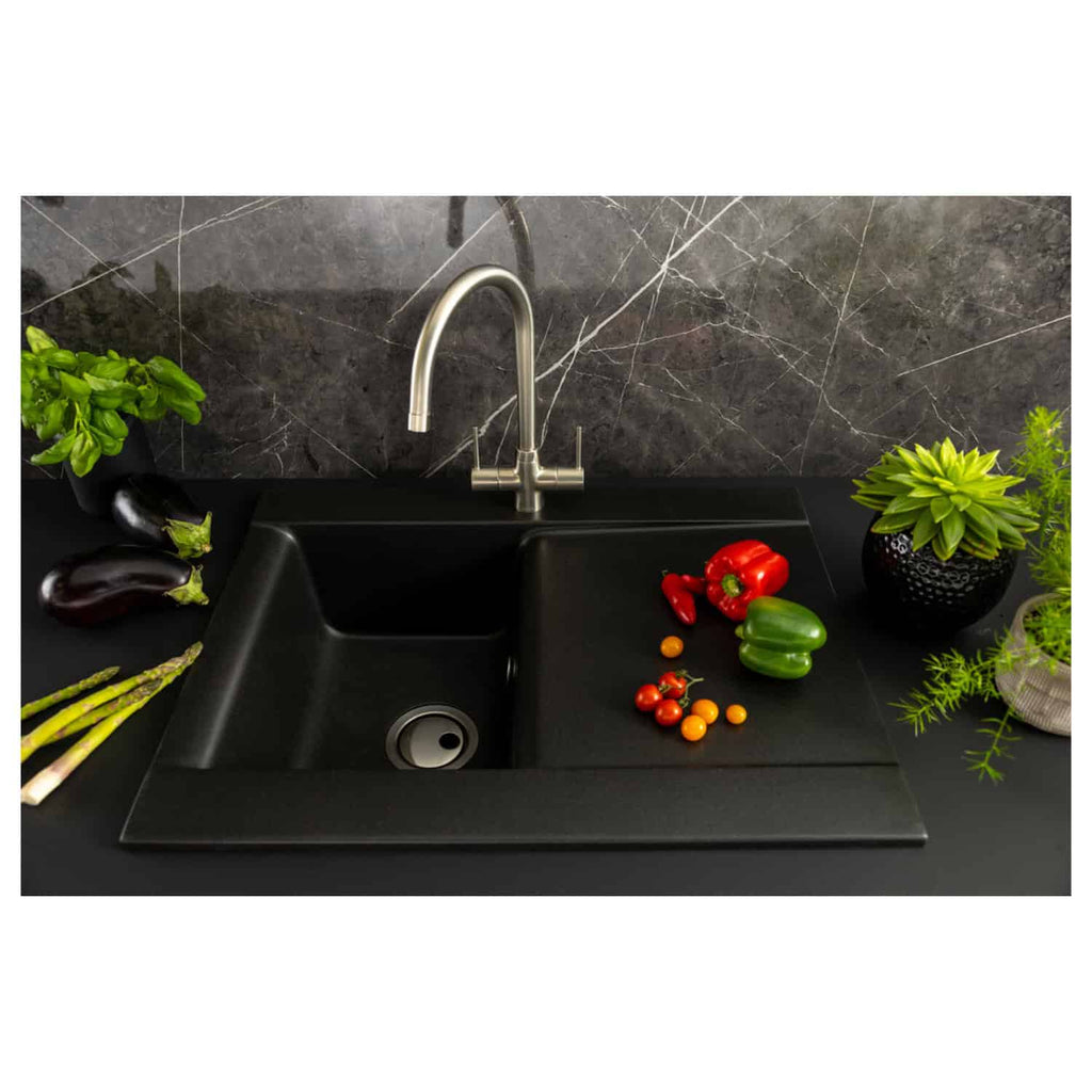 Black kitchen sink with modern stainless steel faucet and fresh vegetables on black countertop with marble backsplash, showcasing stylish and functional Bubly Bathrooms design.