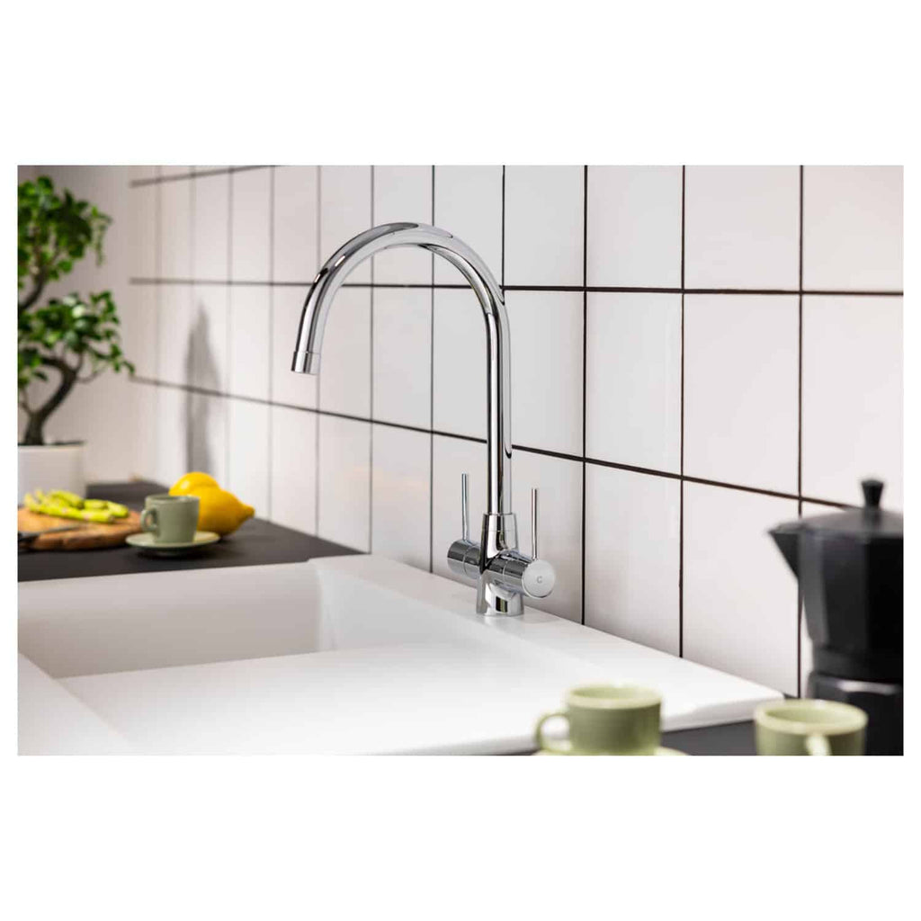Sleek chrome kitchen tap with high-arc design installed above a white ceramic sink in a modern kitchen setting. Perfect for stylish kitchen renovations and modern bathroom designs.