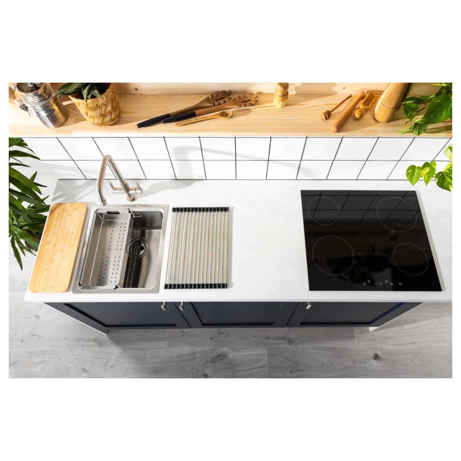 Modern compact kitchen with stainless steel sink, black induction hob, and stylish navy cabinets, featuring minimalist countertop and natural wood accents, perfect for contemporary home kitchens.