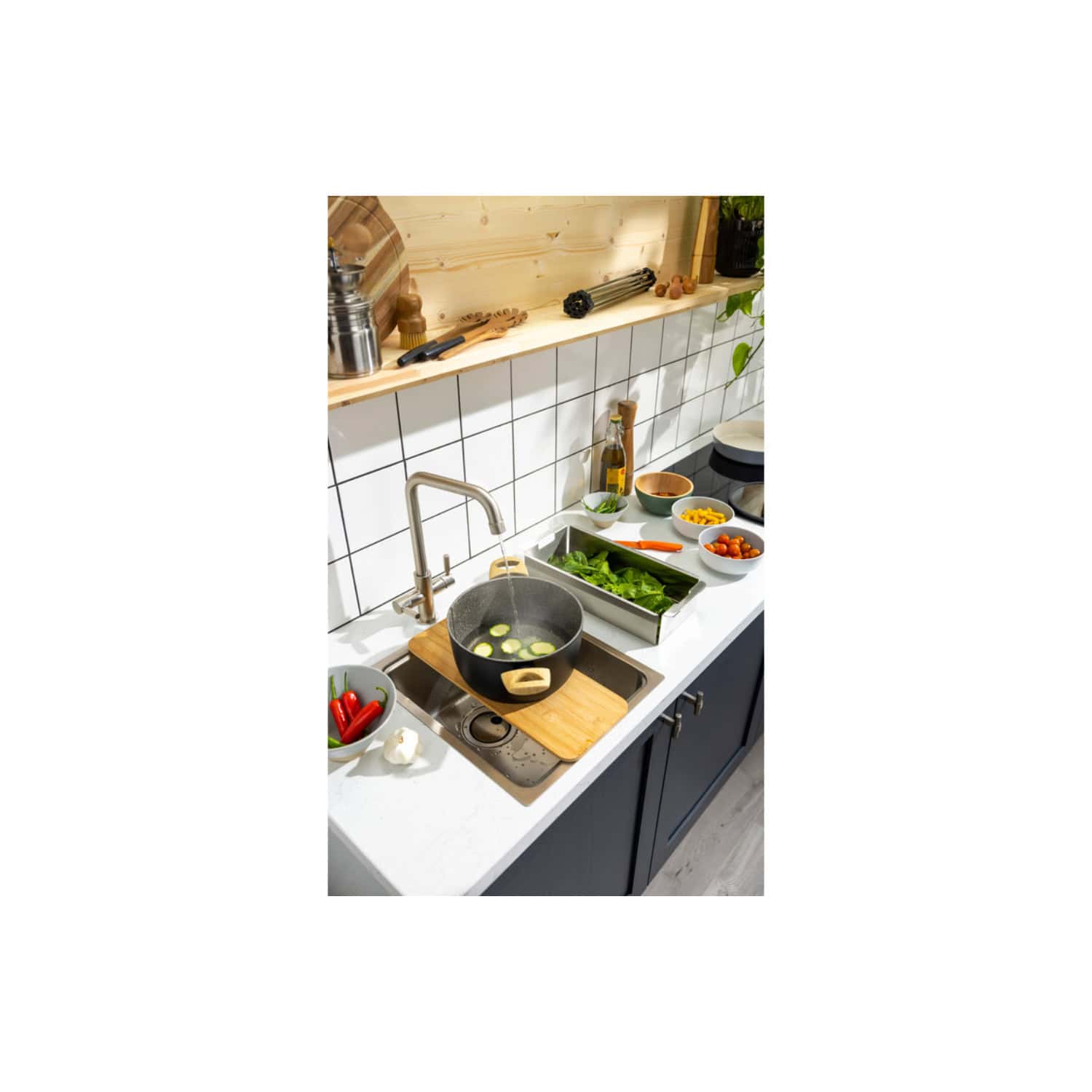 Sleek modern kitchen with white tiled backsplash, stainless steel sink, and fresh vegetables, ready for cooking in a stylish Bubly Bathrooms setting.