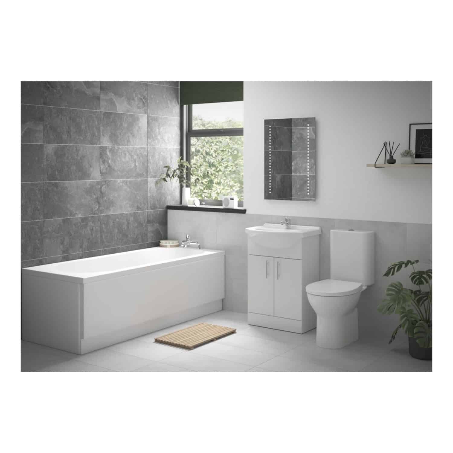 Bright modern bathroom with white bathtub, vanity sink, toilet, grey textured wall tiles, and minimalist decor featuring plants and wall mirror, perfect for contemporary bathroom designs.