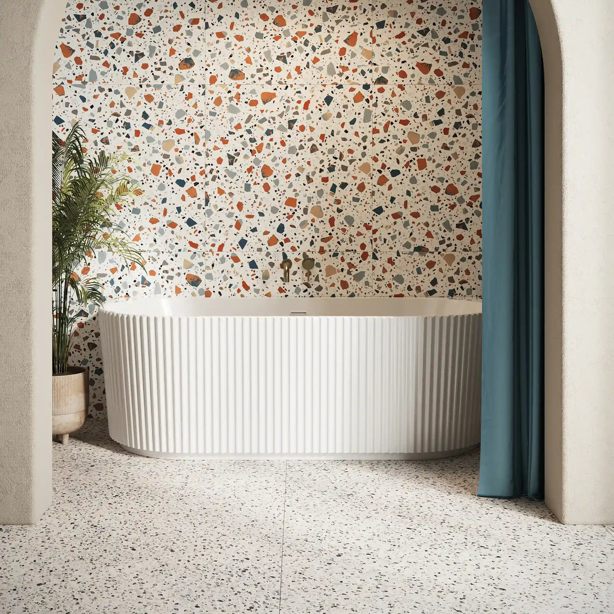 Luxurious freestanding bathtub with ribbed exterior in a modern bathroom featuring terrazzo flooring and a colourful terrazzo wall, complemented by natural elements and elegant design details.