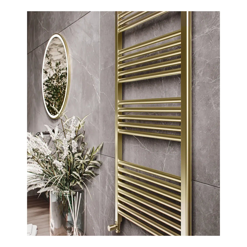 Polished gold towel radiator in modern bathroom with marble wall tiles and decorative plant.