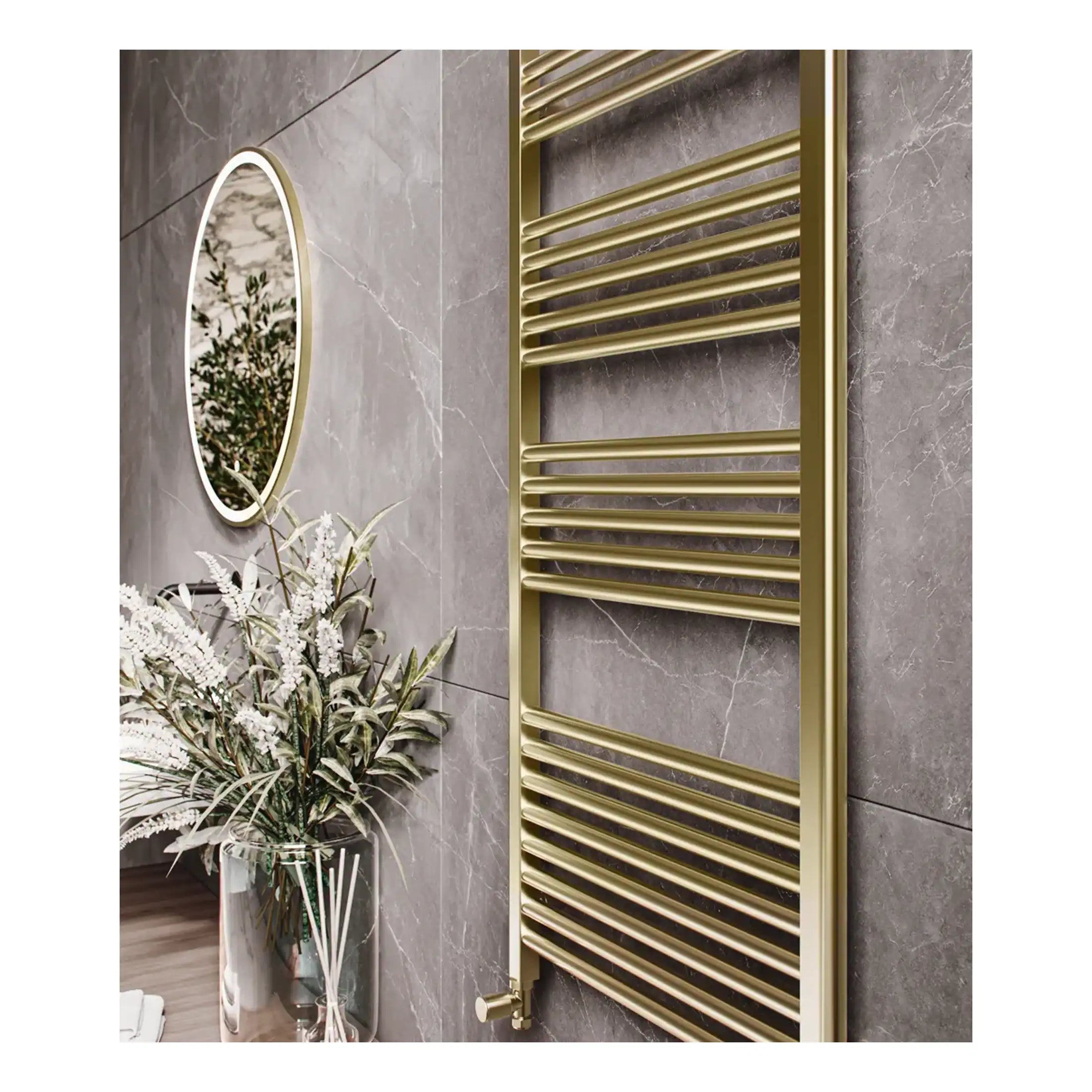Polished gold towel radiator in modern bathroom with marble wall tiles and decorative plant.
