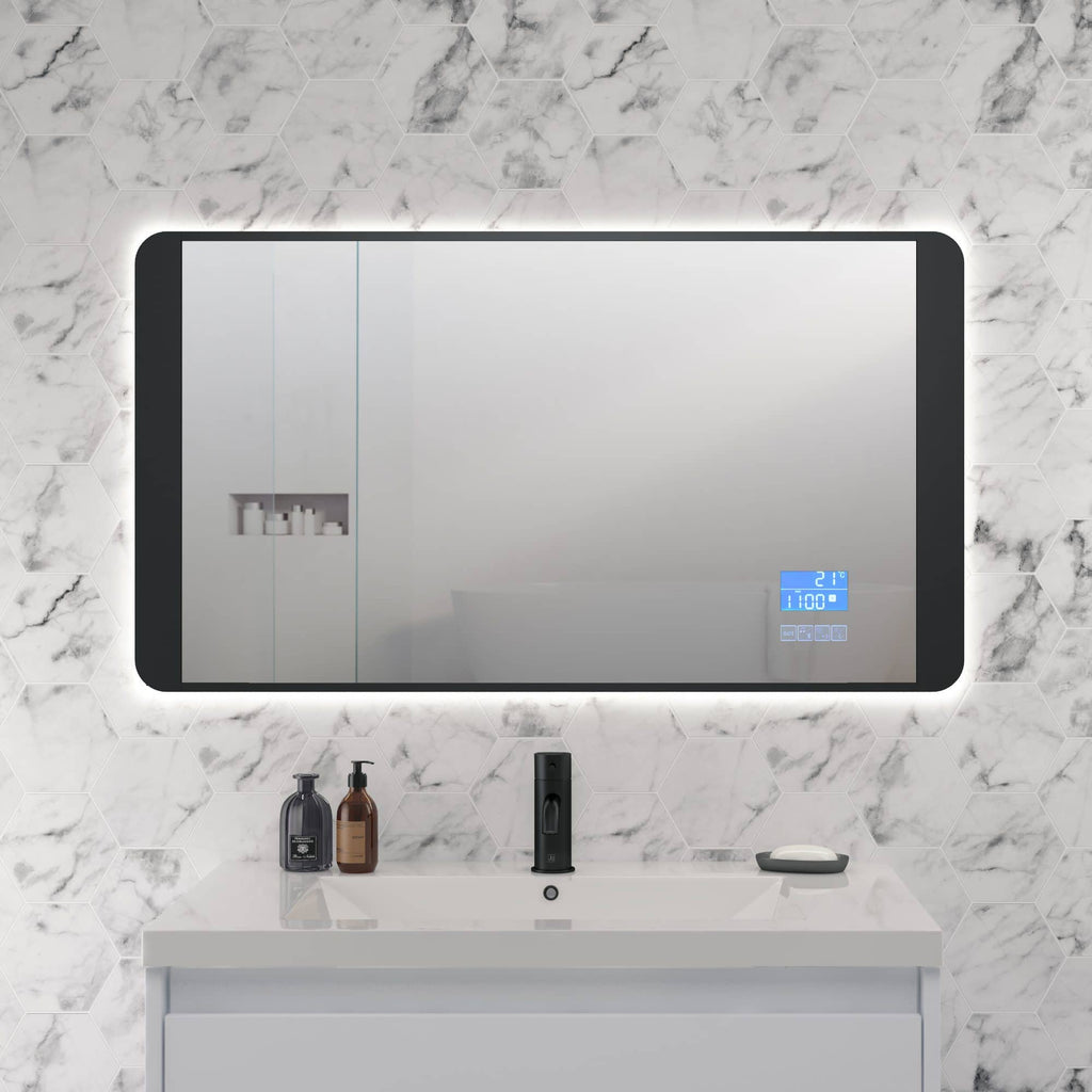 Sleek modern bathroom mirror with built-in digital clock and temperature display, mounted on a white marble wall, with a minimalist white vanity below.