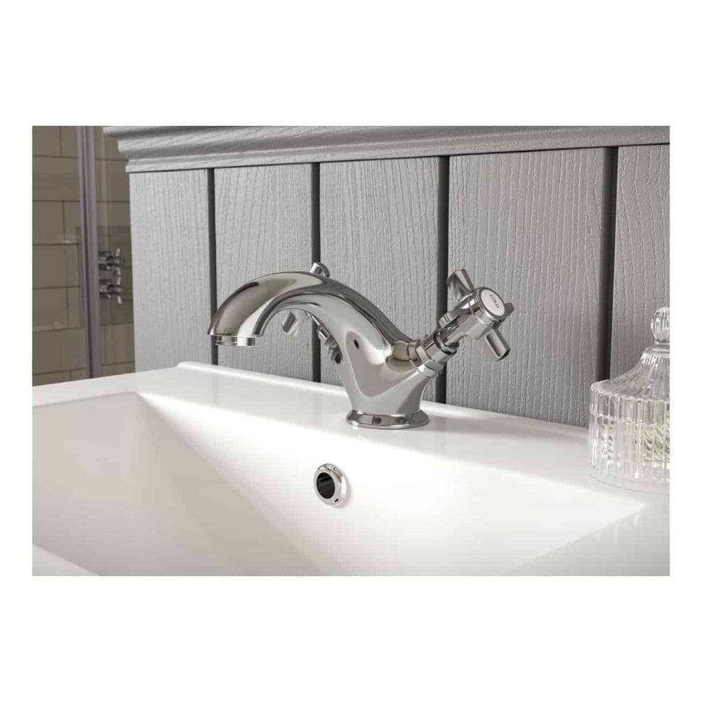 Shiny chrome bathroom sink mixer tap installed on a white ceramic basin in a modern bathroom setting.