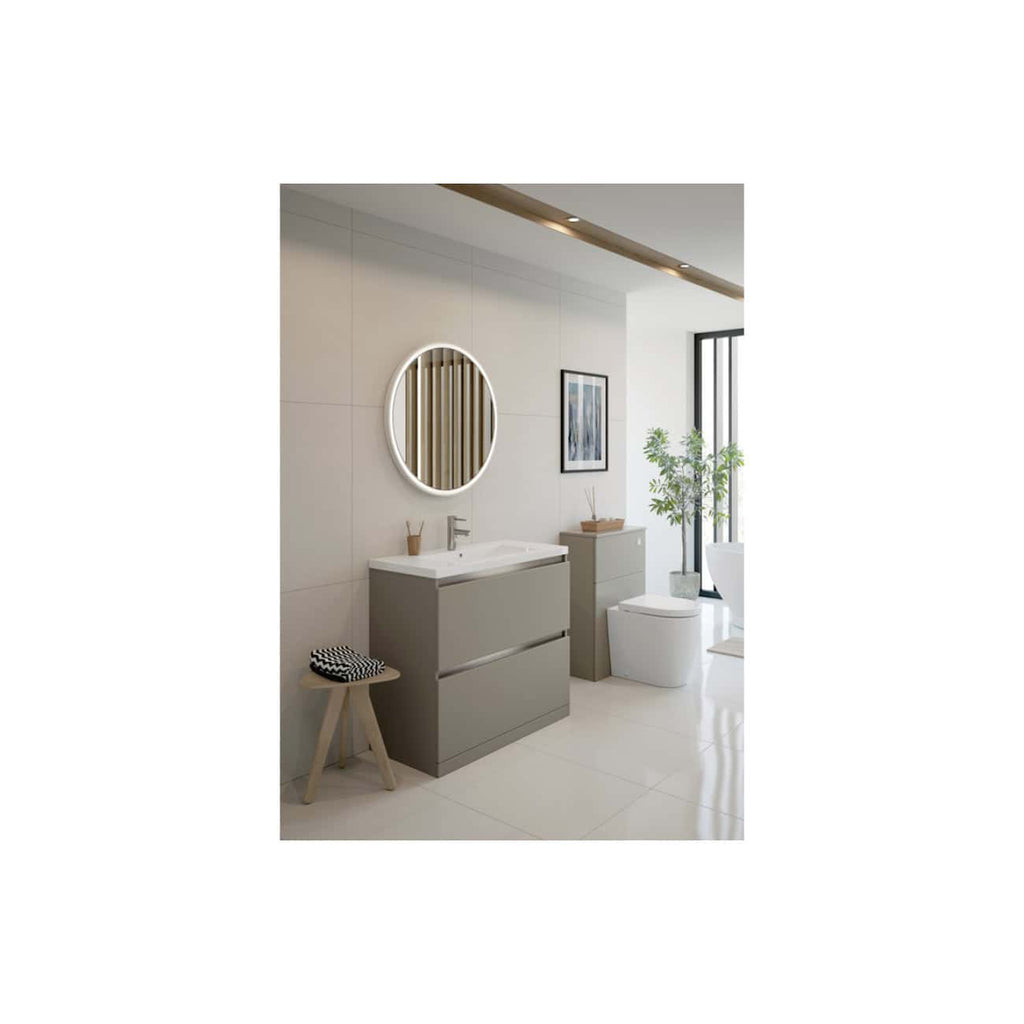 Contemporary bathroom featuring modern grey vanity units, a sleek white toilet, round mirror with LED lighting, artwork, and green plants, creating a stylish and functional space.