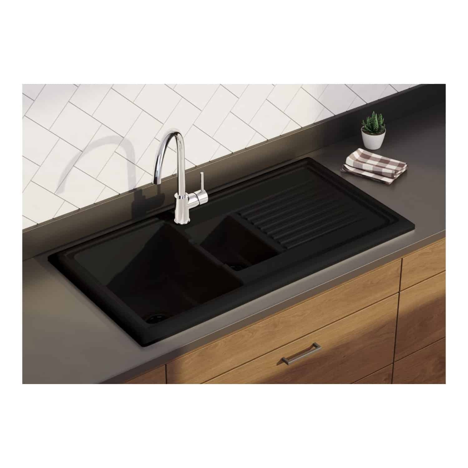 Black kitchen sink with integrated draining board and modern chrome faucet, set on a wooden countertop with white brick tiling backsplash. Perfect for contemporary bathroom or kitchen environments.