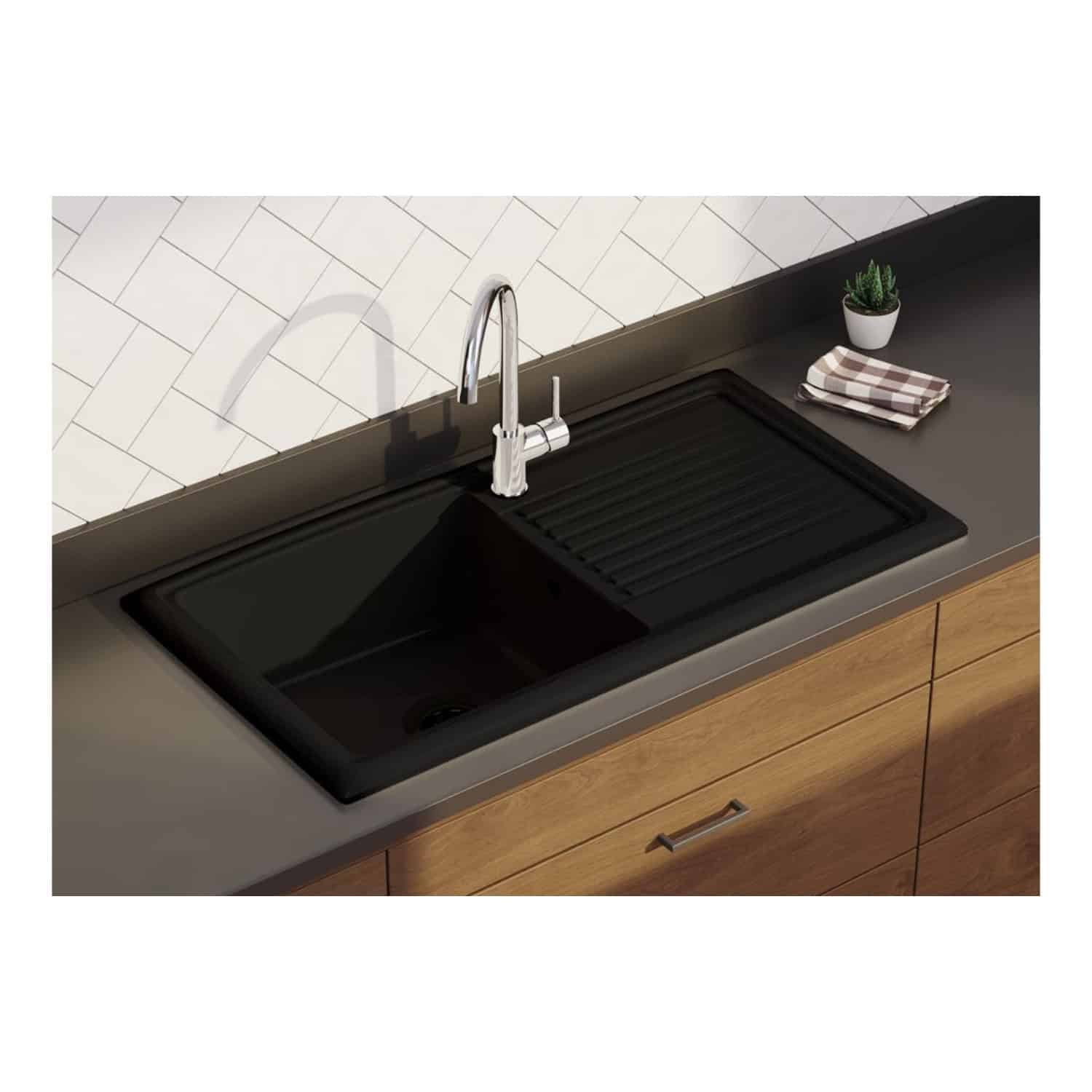 Modern black kitchen sink with integrated draining board, chrome faucet, and wooden cabinetry, set against a white tile backsplash – perfect for contemporary Bubly bathroom and kitchen designs.