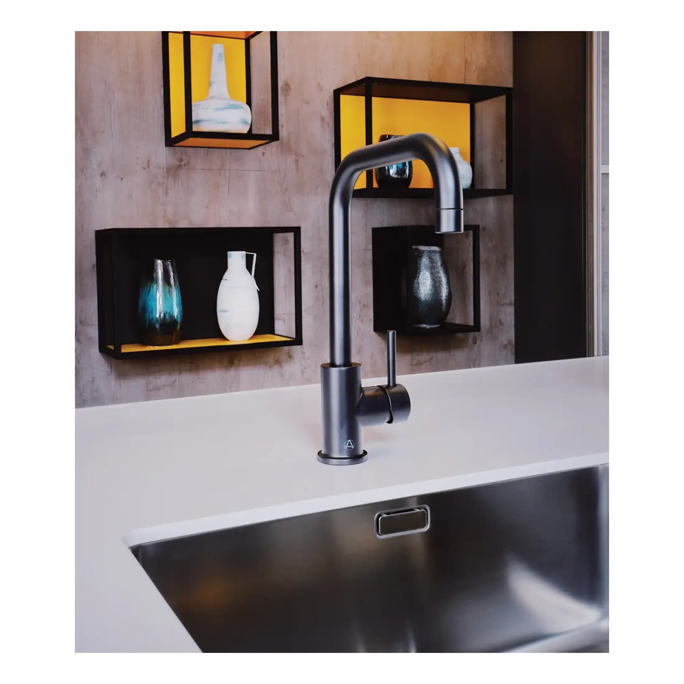 Sleek stainless steel kitchen tap with modern design over a white quartz kitchen worktop.
