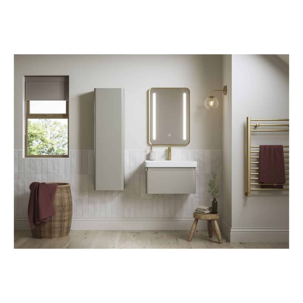 Sleek modern bathroom featuring minimalist white vanity with illuminated mirror, tall storage cabinet, wall-mounted light fixture, and gold towel radiator, with natural light from window and neutral tones for a contemporary look.