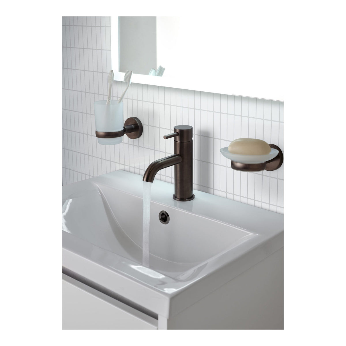 Sleek white bathroom sink with a modern bronze faucet and matching accessories, including toothbrush holder and soap dish, creating a stylish and functional bathroom décor.