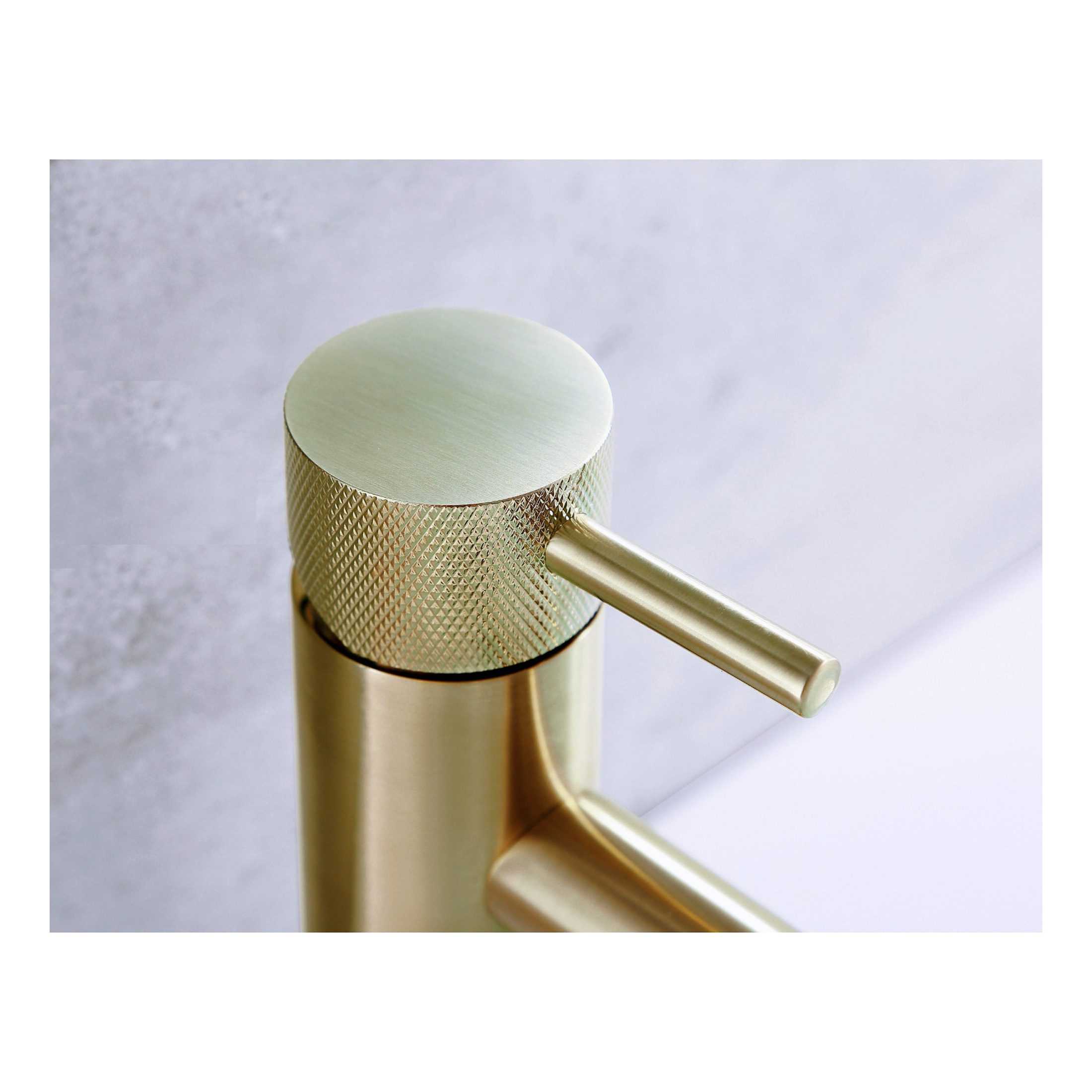 Sleek gold bathroom tap with textured grip handle, modern design, and minimalist aesthetic. Perfect for contemporary bathroom upgrades.