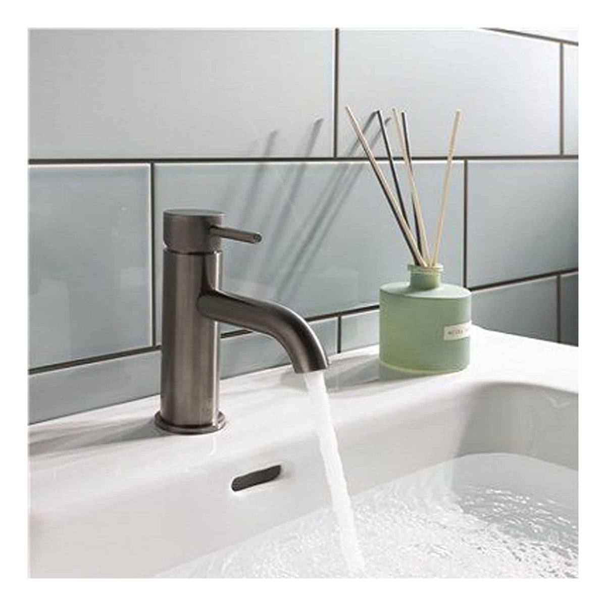 Freshwater bathroom sink with modern stainless steel tap and decorative reed diffuser, clean and stylish bathroom fixtures for a contemporary bathroom design.