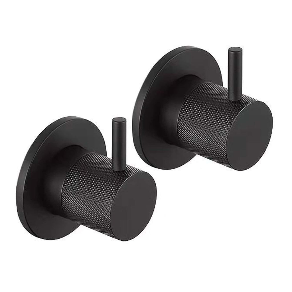 Black minimalist bathroom wall hooks for modern interiors, featuring textured cylindrical design with loop handles, ideal for hanging towels, robes, or accessories in contemporary bathroom spaces.