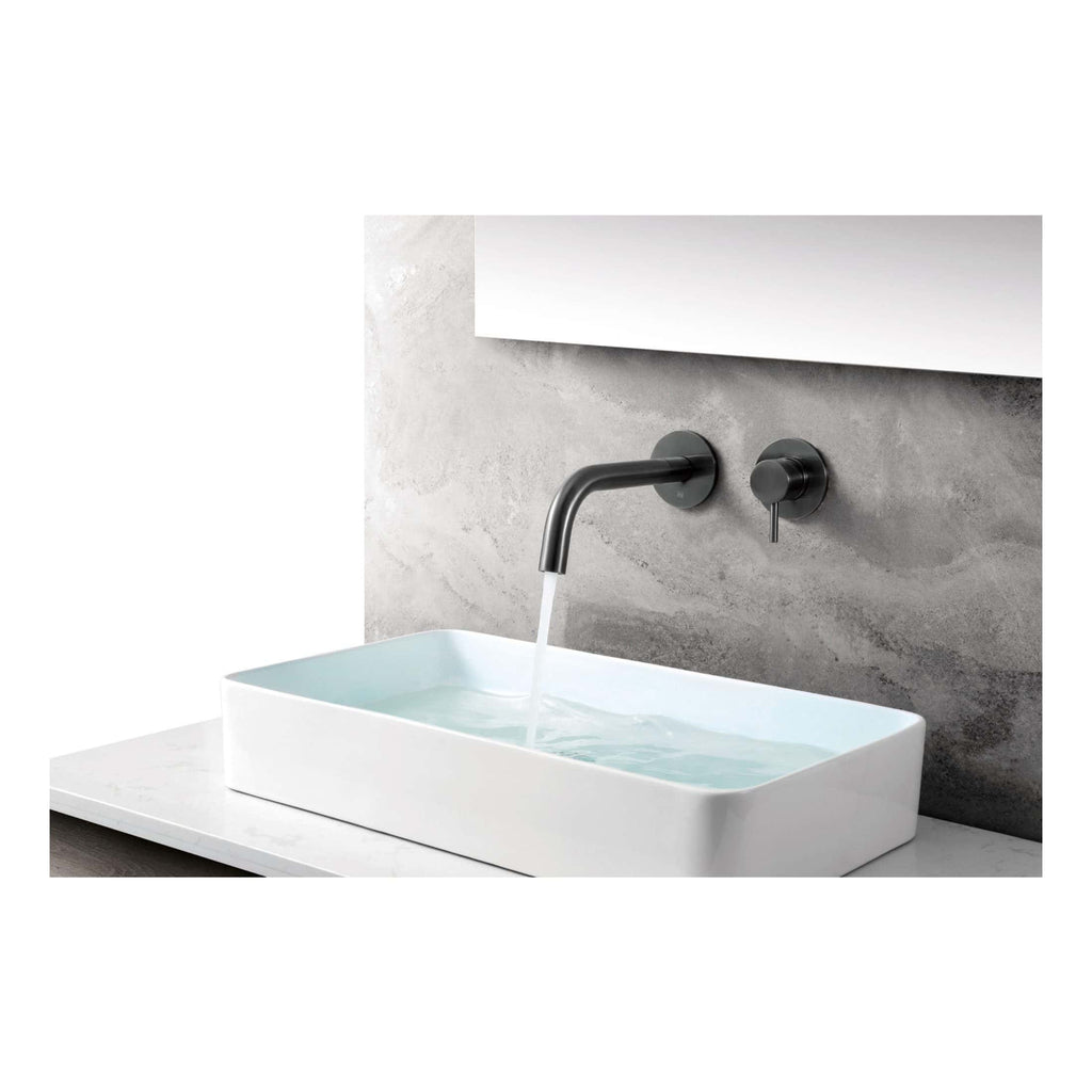 Sleek modern bathroom sink with wall-mounted matte black faucet and handle, set against a textured grey wall, ideal for contemporary bathroom designs.