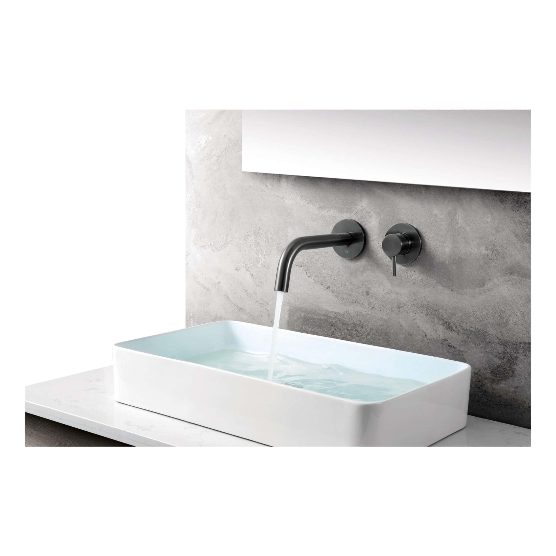 Sleek modern bathroom sink with wall-mounted matte black faucet and handle, set against a textured grey wall, ideal for contemporary bathroom designs.
