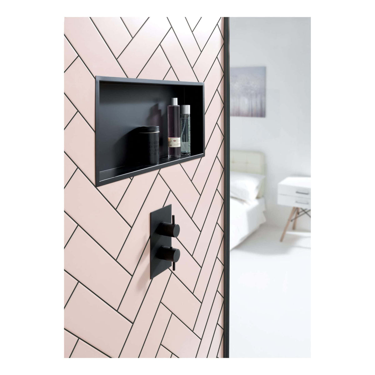 Sleek black shower control with built-in niche for bath products, set against modern geometric pink and black tiled bathroom wall.