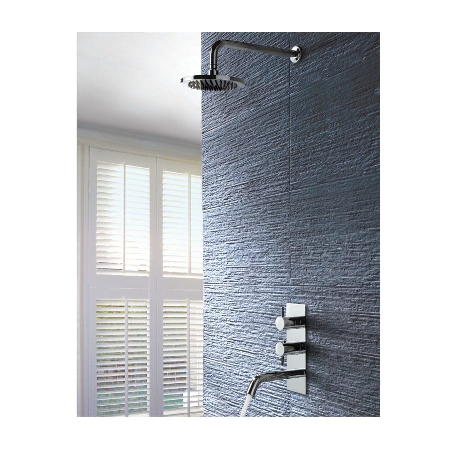 Showerhead and modern mixer tap installed on textured blue wall in contemporary bathroom setting. Natural light from window with white shutters enhances the sleek, stylish shower design. sleek bathroom shower, modern bathroom fixtures, textured wall decor, bathroom renovation ideas, bathroom design inspiration.