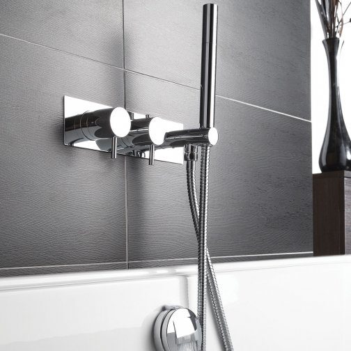 Chrome bathroom shower tap and handheld shower head mounted on grey tiled wall, modern bathroom fixture, concept of bathroom renovations and quality bathroom fittings, Bubly Bathrooms.