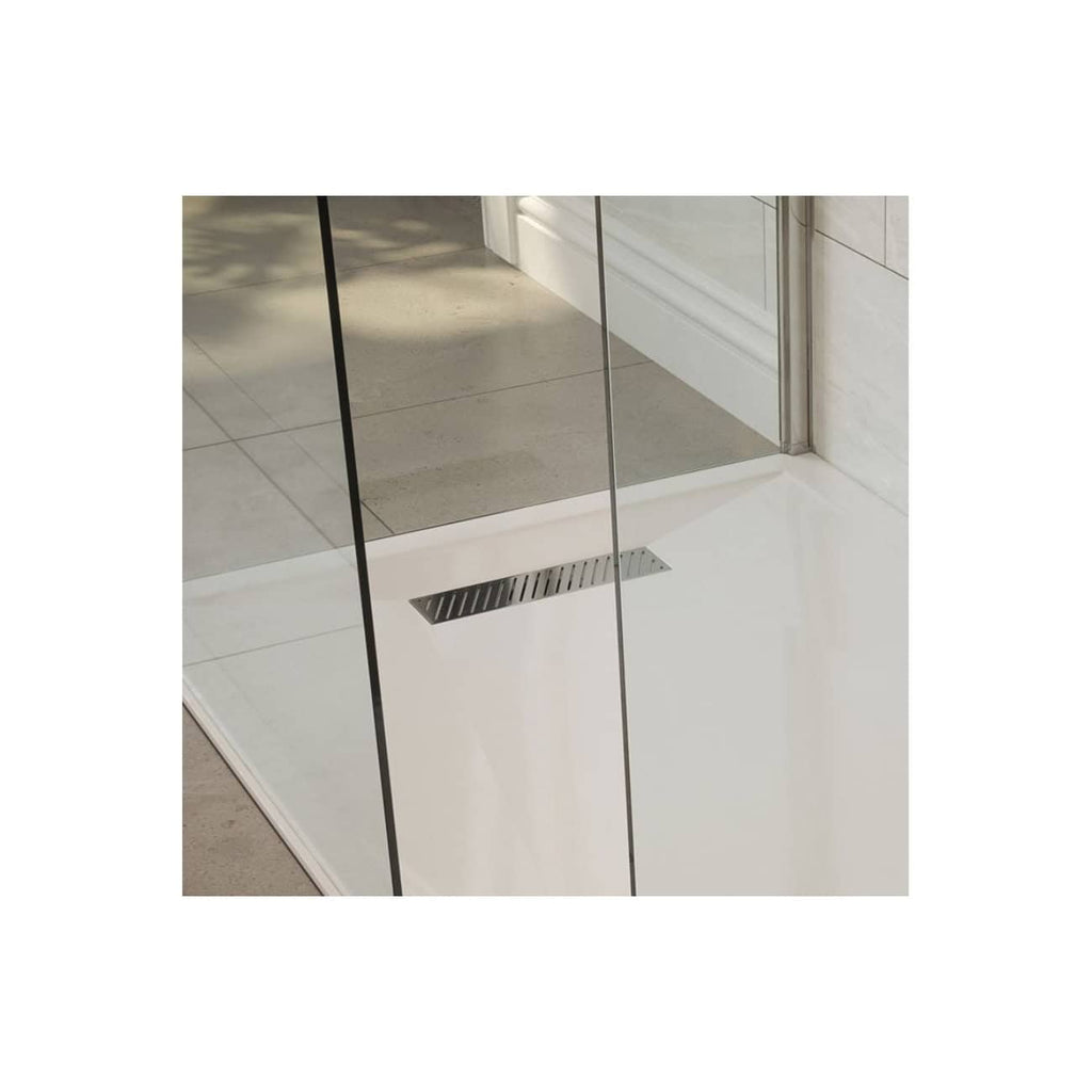 Shower drain installed on a modern tiled bathroom floor with glass shower enclosure, showcasing sleek bathroom design and high-quality fixtures.