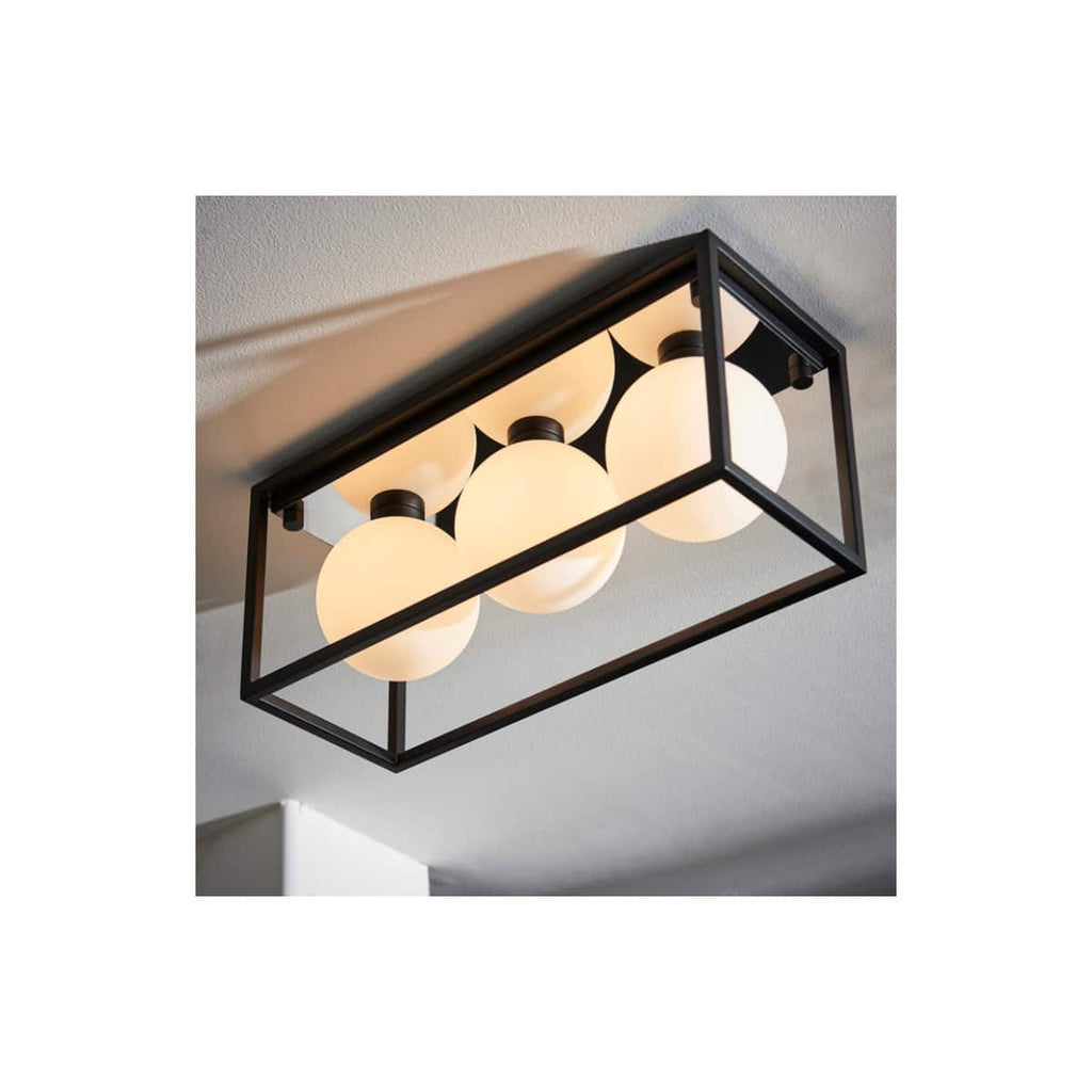 Modern ceiling bathroom light fixture with four spherical frosted glass globes encased in a sleek black metal frame, ideal for contemporary bathrooms.
