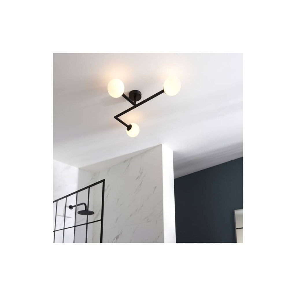 Modern black ceiling light fixture with three globe bulbs in a contemporary bathroom setting.