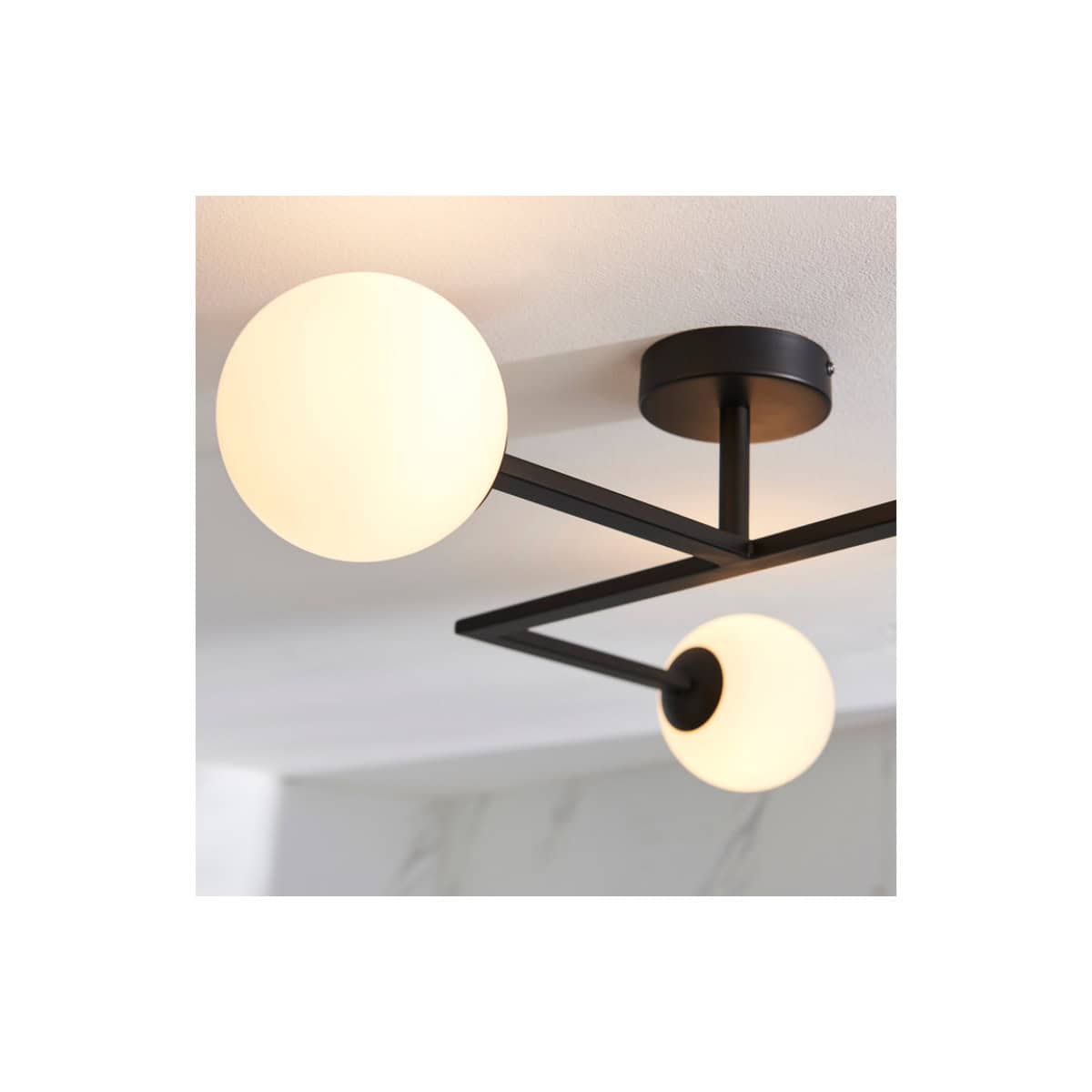 Modern black and white ceiling light fixture with spherical glass shades, ideal for contemporary bathroom and interior lighting designs.