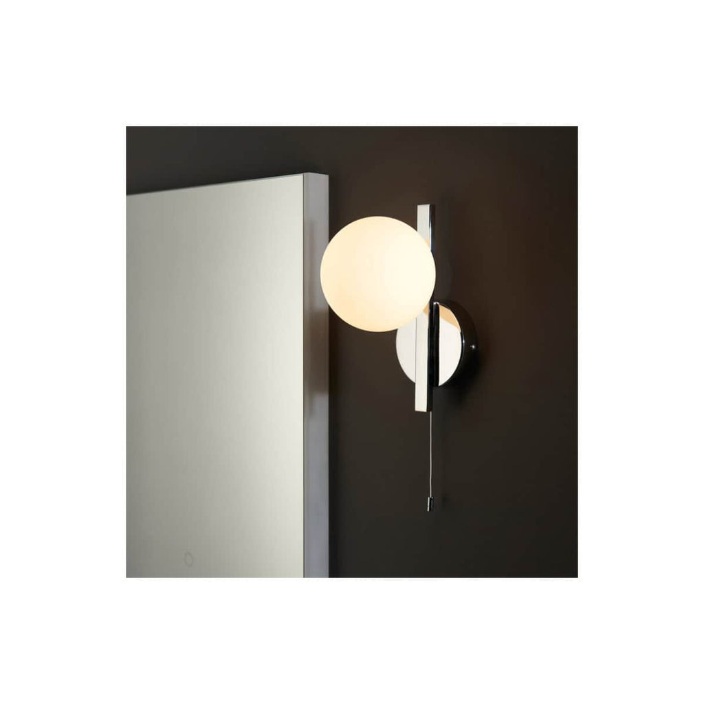 Stylish modern wall sconce with spherical frosted glass shade and sleek chrome finish, ideal for contemporary bathroom lighting and bathroom makeover designs.