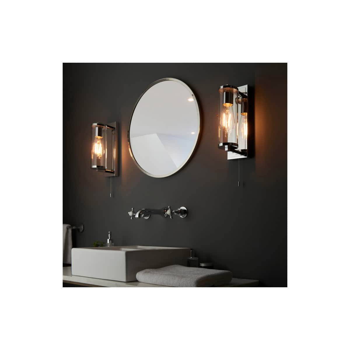 Sleek wall-mounted bathroom vanity with modern black and white design, complemented by stylish wall sconces and a large oval mirror for contemporary bathroom aesthetics.