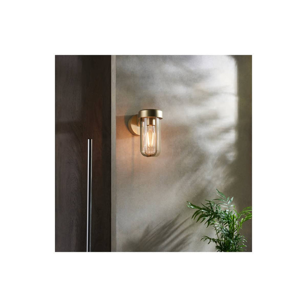 Contemporary wall-mounted bathroom light fixture with clear glass shade and warm LED glow, enhancing modern bathroom decor and ambiance. Perfect for stylish bathroom lighting solutions.
