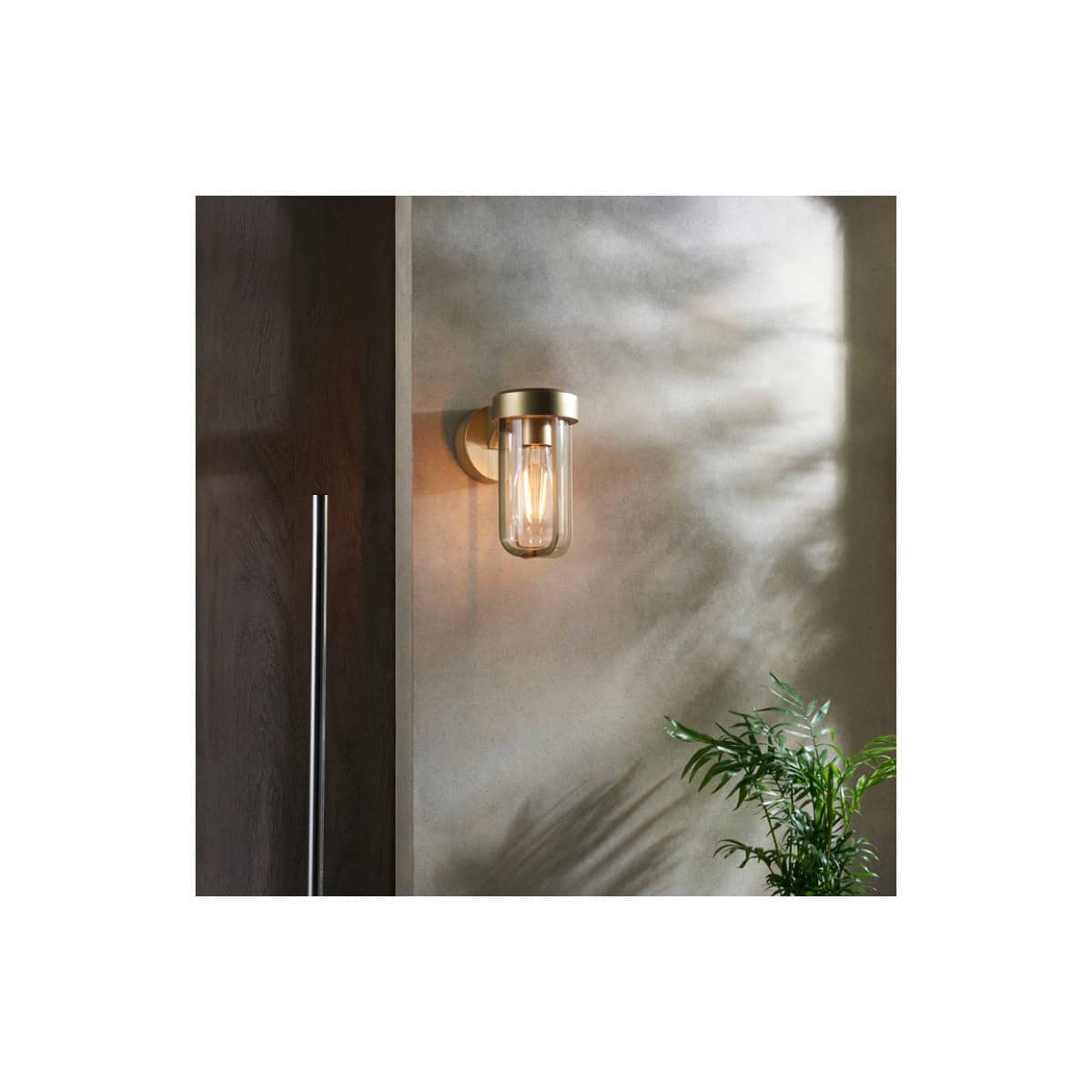 Contemporary wall-mounted bathroom light fixture with clear glass shade and warm LED glow, enhancing modern bathroom decor and ambiance. Perfect for stylish bathroom lighting solutions.