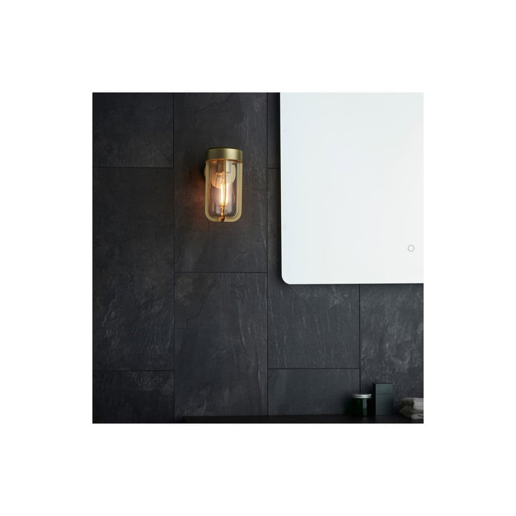 Sleek modern bathroom wall with black slate tiles, illuminated wall sconce, and minimalist mirror, showcasing contemporary bathroom design and lighting for a stylish, functional space.