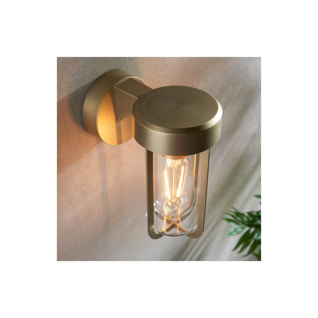 Industrial-style wall-mounted LED bathroom light fixture with a brass finish and exposed filament bulb, perfect for modern bathroom decor.