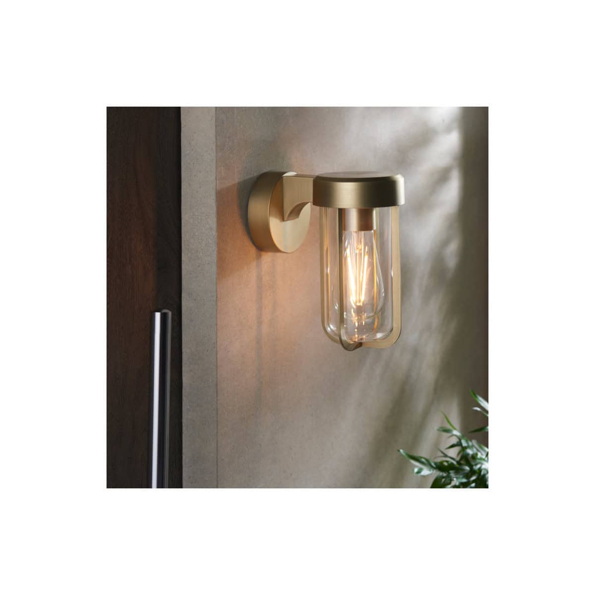 Modern industrial-style wall sconce bathroom lighting in brass with clear glass shade, ideal for contemporary bathroom decor and stylish lighting solutions.
