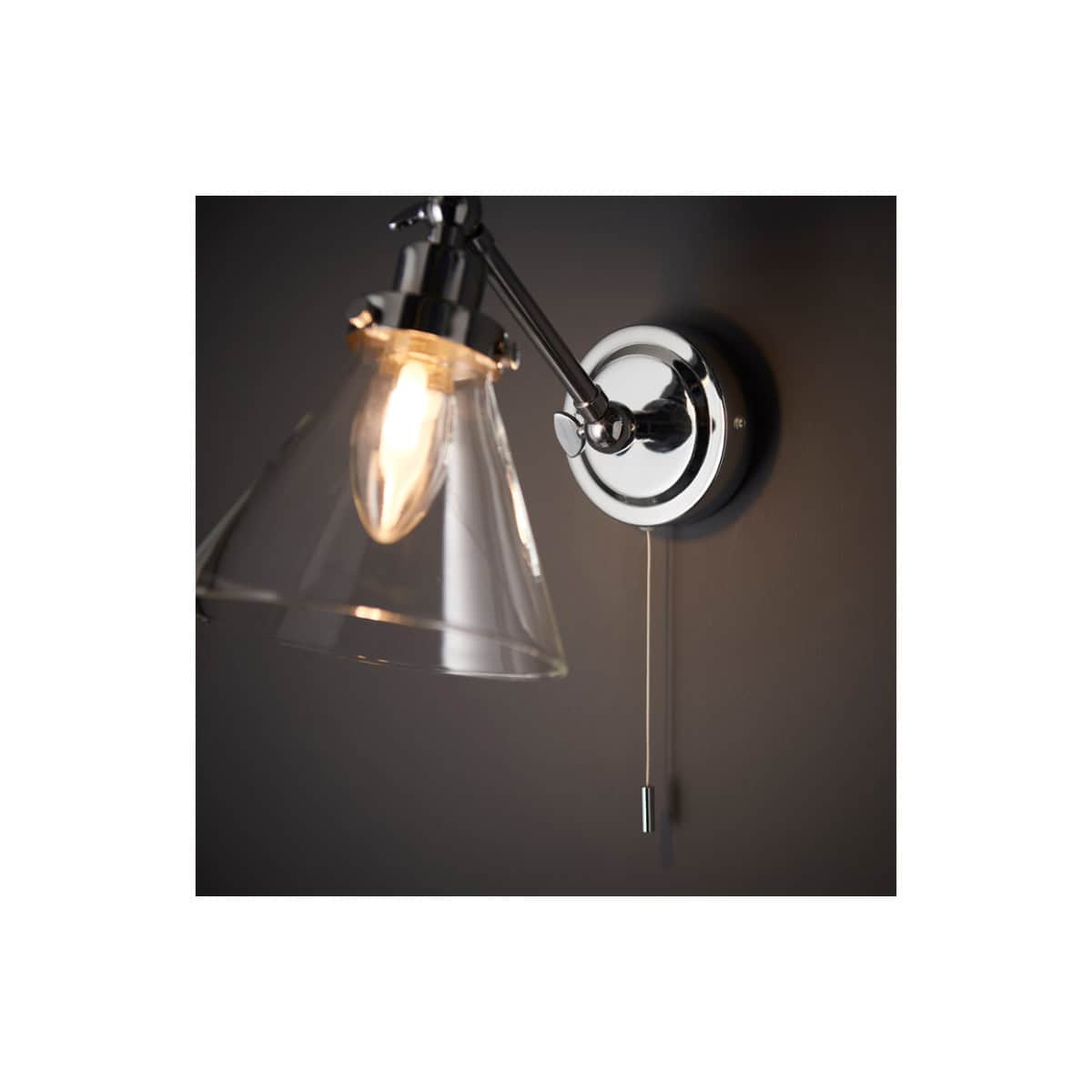 Modern chrome wall-mounted bathroom sconce with glass shade, ideal for elegant bathroom lighting solutions. Perfect for contemporary interiors and enhancing bathroom decor.