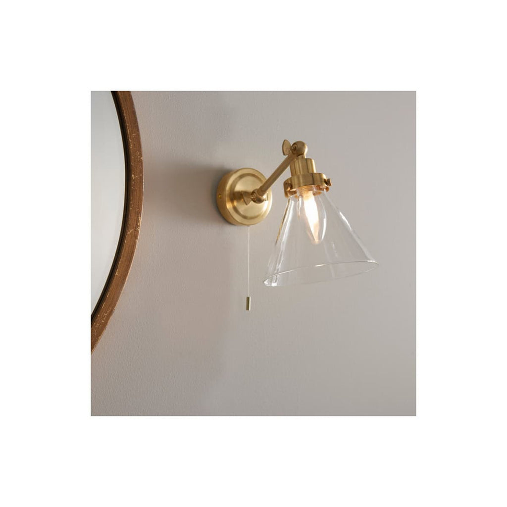 Elegant brass wall sconce with glass shade, ideal for modern and vintage bathroom lighting. Perfect for creating warm ambience in Bubly Bathrooms' stylish designs.