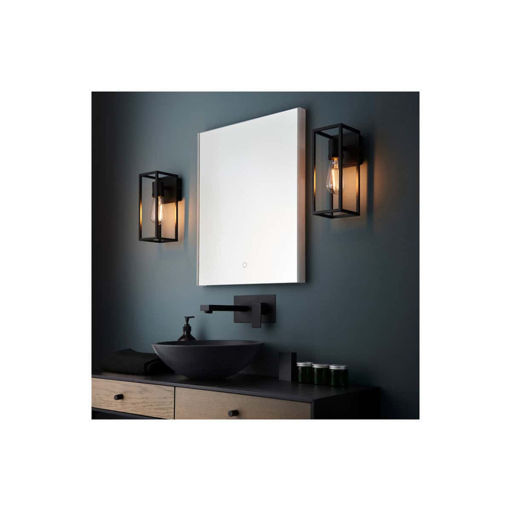 Contemporary bathroom wall with modern black vanity mirror, stylish black wall sconces with Edison bulbs, and minimalist black faucet for a sleek, modern bathroom design.