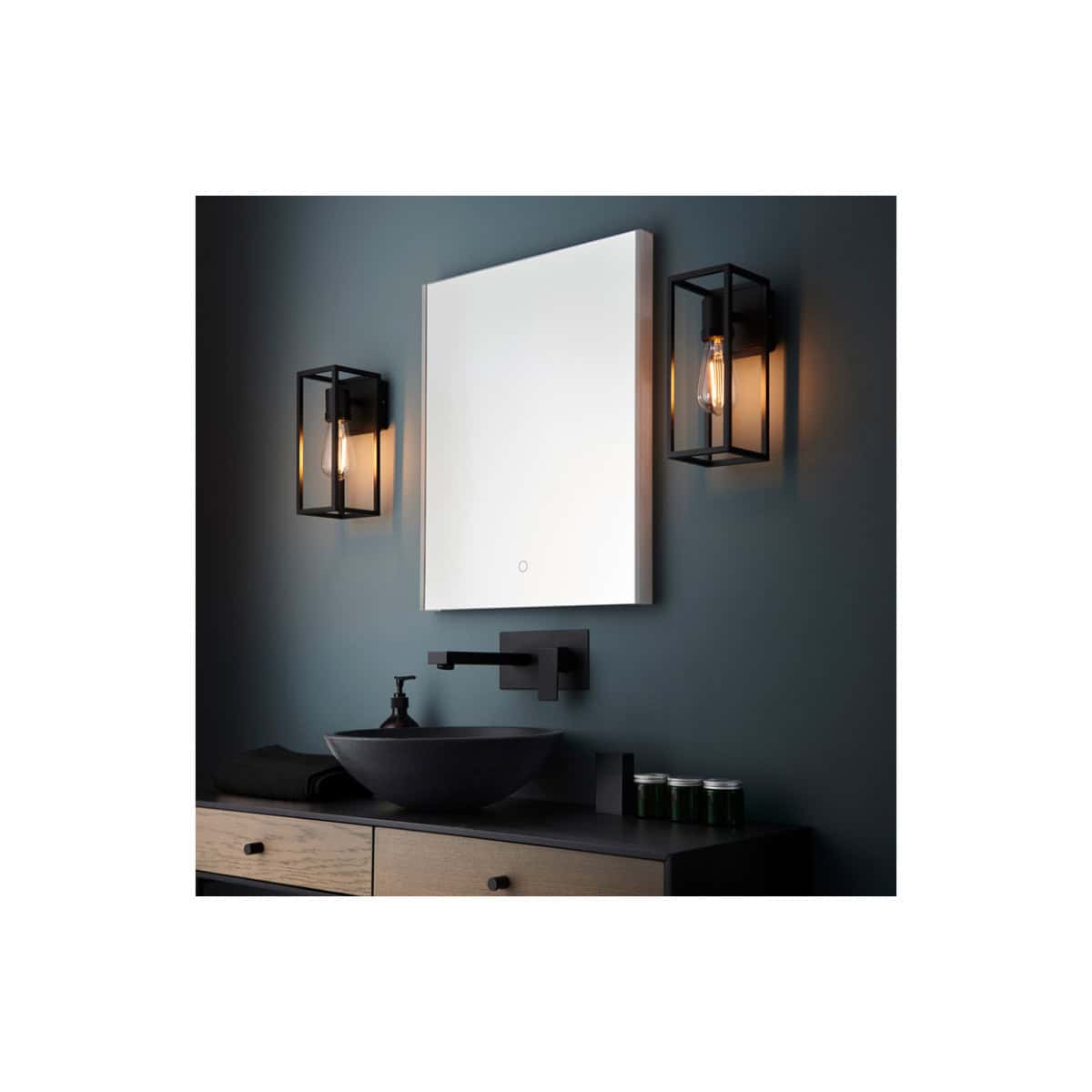 Contemporary bathroom wall with modern black vanity mirror, stylish black wall sconces with Edison bulbs, and minimalist black faucet for a sleek, modern bathroom design.