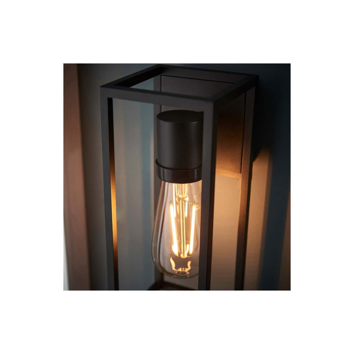 Vintage wall-mounted bathroom light fixture with exposed filament bulb, black metal frame, modern industrial design, perfect for enhancing bathroom aesthetics and lighting.