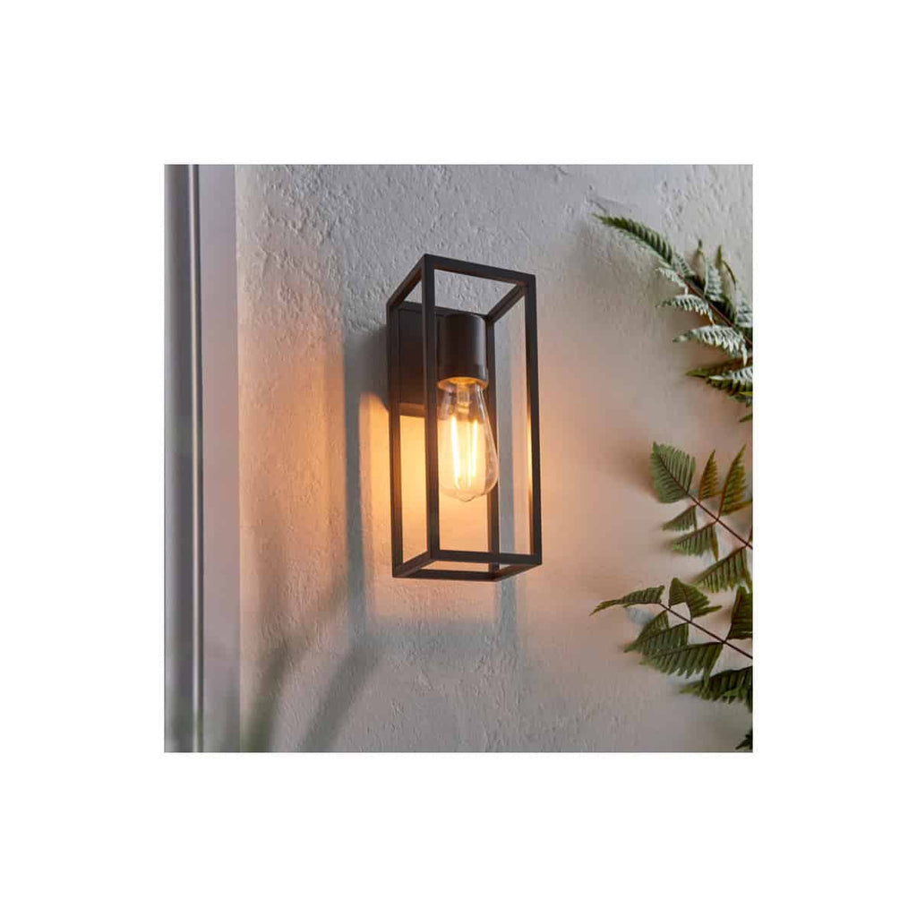 Sleek modern black metal wall sconce with exposed Edison-style bulb, perfect for bathroom lighting or decorative indoor lighting.