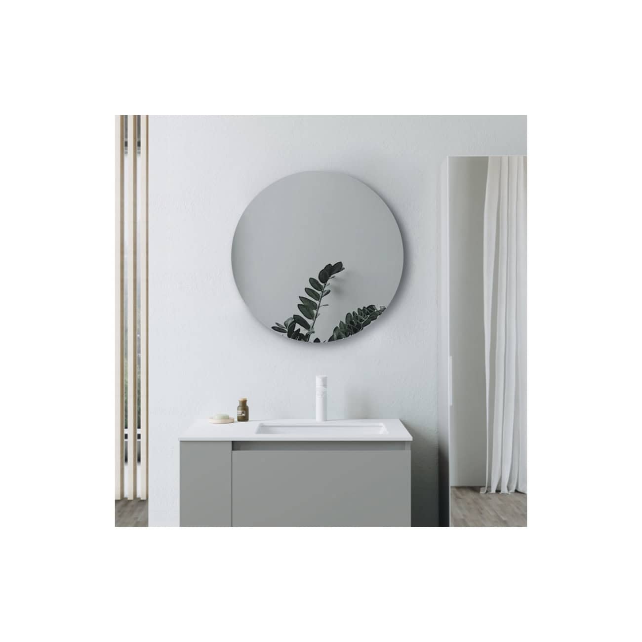 Sleek modern bathroom vanity with a large round mirror, minimalist design, and natural decor elements creating a clean, contemporary look for stylish bathroom spaces.