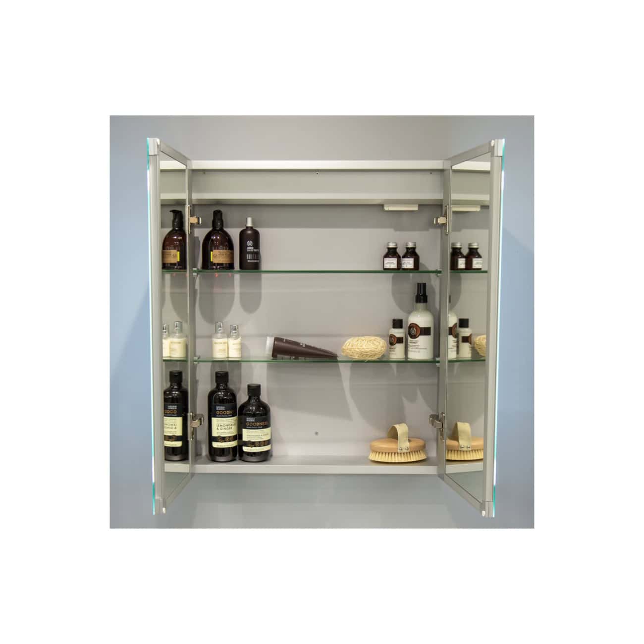 Shower cabinet with glass shelves filled with toiletries and bathroom products, set against a light wall. Modern bathroom storage with organisational space for various personal care essentials.