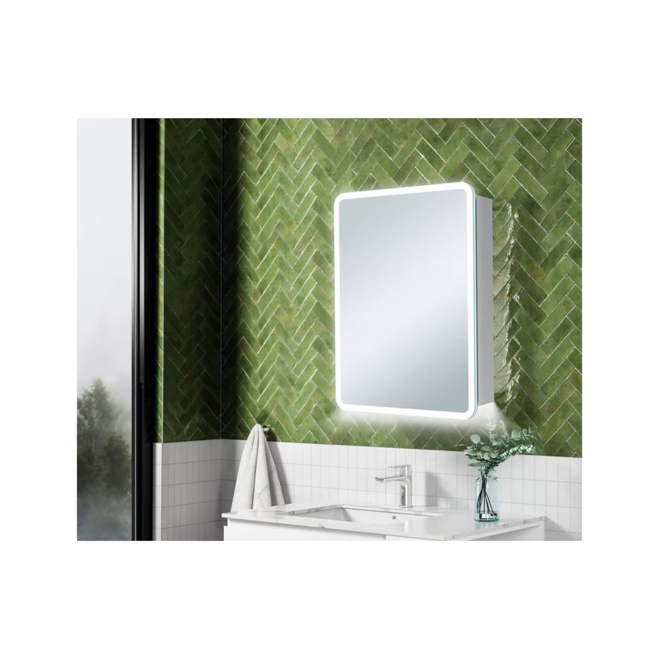 Sleek illuminated bathroom mirror with LED lighting above a modern white vanity, featuring a chrome faucet, set against a vibrant green tile wall in a contemporary bathroom design.