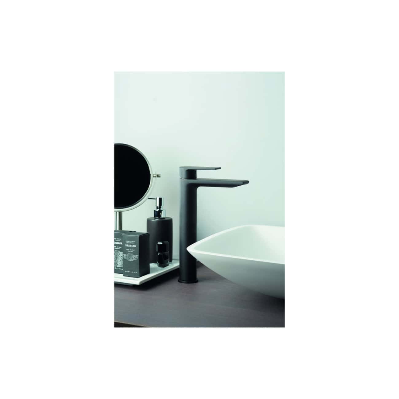 Minimalist black bathroom faucet with white vessel sink and bathroom toiletries on a dark vanity table, modern bathroom décor emphasizing sleek design and contemporary style.