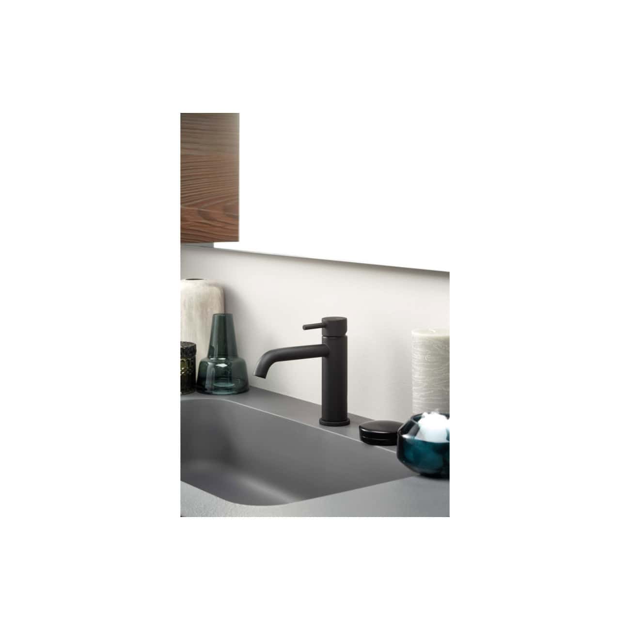 Sleek matte black kitchen sink faucet with a modern design and high arc spout, surrounded by decorative glass vases and accessories in a contemporary kitchen setting.