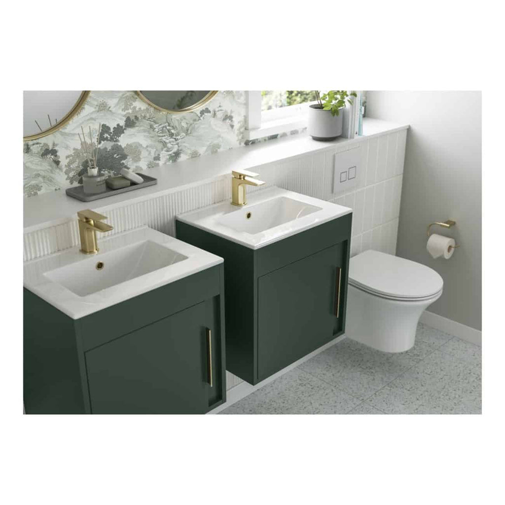 Contemporary bathroom vanity units with dual sinks, featuring stylish gold fixtures, modern cabinetry in dark green, and a sleek toilet for a functional and elegant space.